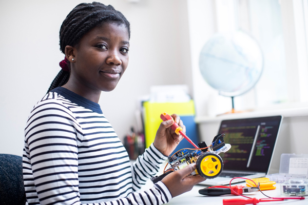 A young woman works on a small engineering project.